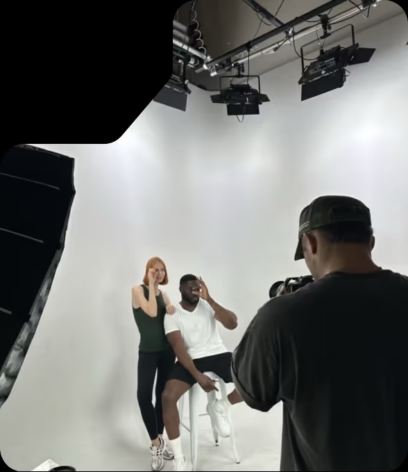 Commercial shoot on our white cyc wall — two talent under studio lights
